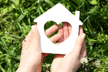 Poster - Female hands holding toy house outdoors