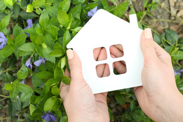 Poster - Female hands holding toy house outdoors