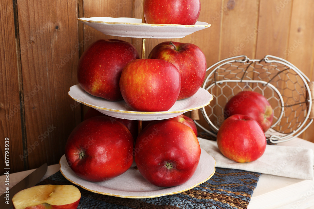 Tasty ripe apples on serving tray on wooden background