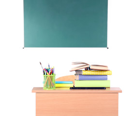 Canvas Print - Wooden desk with stationery and chair in class on blackboard background