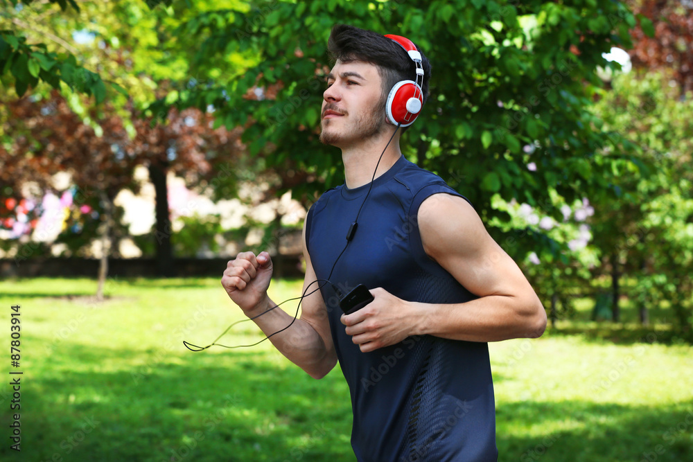 Man jogging with headphones in park