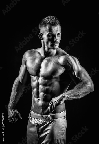 Naklejka nad blat kuchenny very muscular handsome athletic man on black background