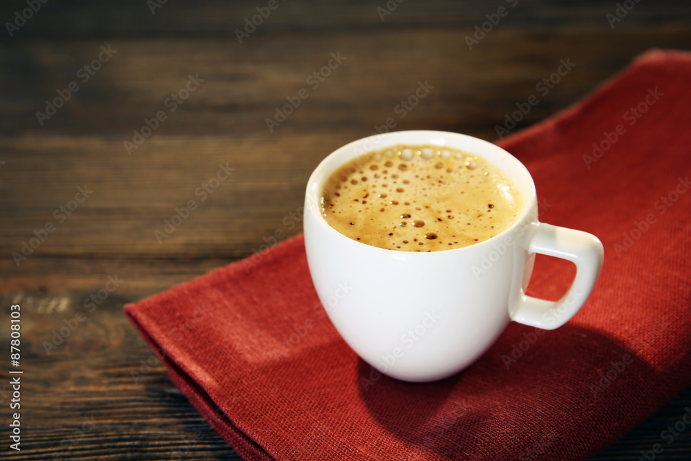 Cup of coffee on napkin on table close up