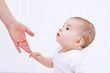 Beautiful baby with mother hands help on white background