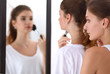 © shefkate - Beautiful girls looking in the mirror and applying cosmetic with