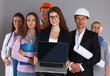 © shefkate - Smiling businesswoman with laptop  and group of industrial