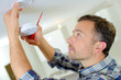 © auremar - Man installing a smoke alarm