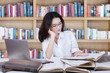 © Creativa Images - Student sitting in library while reading books