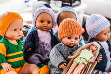 Display Of Old Plastic Dolls And Baby Dolls Wearing Home-made Knitwear Sold At Flea Market Or Garage Sale For Antique Collection Or Knitting Fans