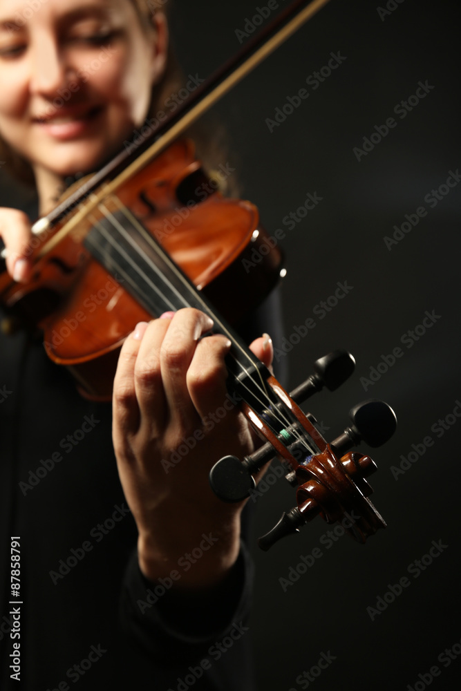 Violinist playing violin on dark background