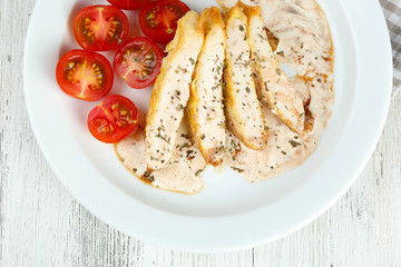 Canvas Print - Slices of chicken fillet with spices and cherry tomato on table close up