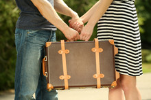 Young Couple Holding Vintage Suitcase Outdoors