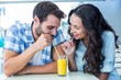 © WavebreakmediaMicro - Cute couple drinking an orange juice together