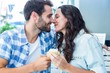 © WavebreakmediaMicro - Couple kissing while holding cupcakes