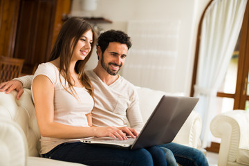 Happy couple using a laptop computer