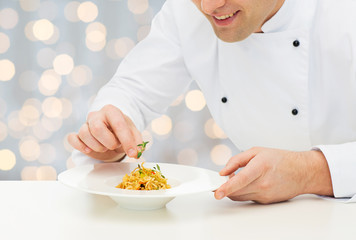 Poster - close up of happy male chef cook decorating dish