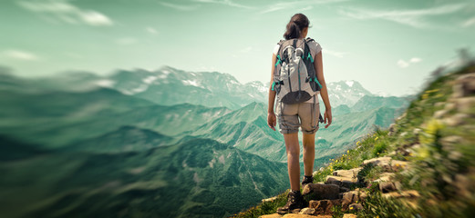 Wall Mural - rear view of woman hiking in mountain range