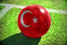 Football Ball With The National Flag Of Turkey Lies On The Green Field Near The White Line