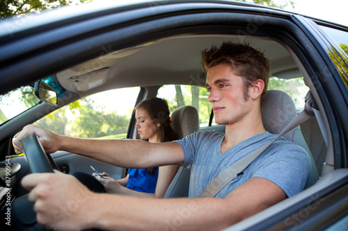 Fotografiet Driving: Driver Paying Attention While Passenger Texts