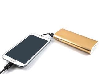 Gold power bank charging white smart phone