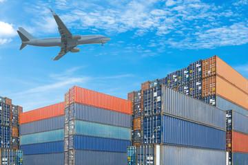 stack of cargo containers with plane against blue sky background