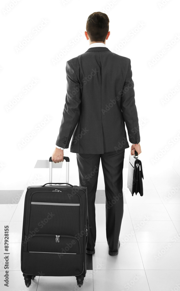 Man holding suitcase on light background