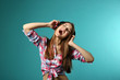 © Africa Studio - Young woman with headphones on turquoise background
