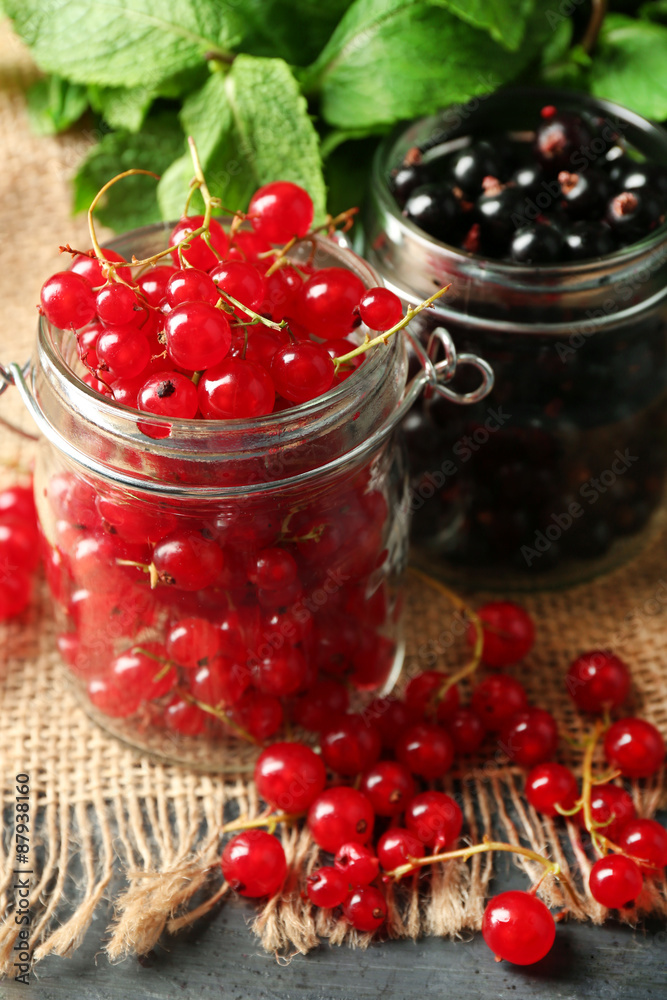 Ripe forest berries in glass jar  on wooden background