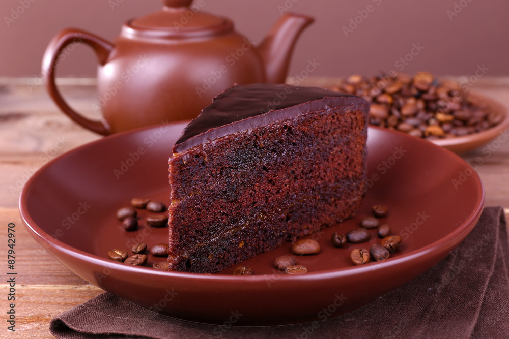 Delicious chocolate cake with coffee beans on plate on table close up