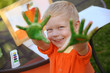 © natalinka29 - Boy with hands painted in green paints ready to make hand prints