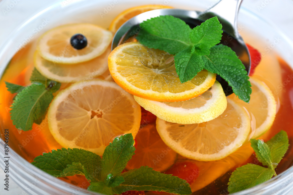 Fruity punch in glass bowl on wooden table, closeup