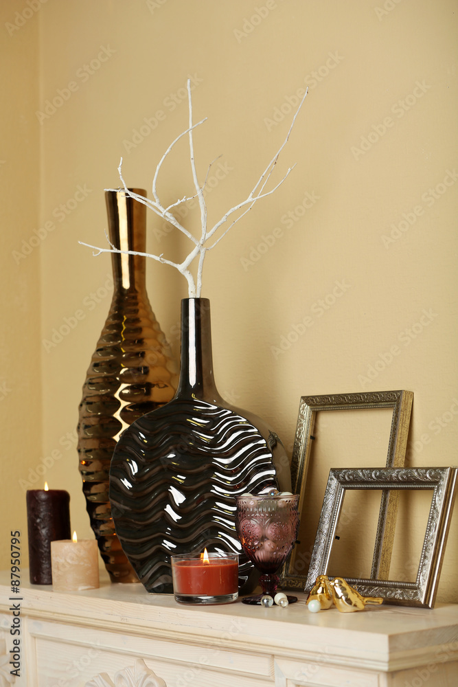 Modern vases with decor on fireplace in room