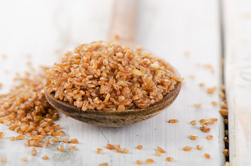 Bulgur in  a old wooden spoon.