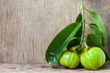 Still life with fresh garcinia cambogia on wooden background 