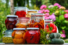 Jars Of Pickled Vegetables And Fruits In The Garden
