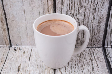 A mug of hot chocolate over wooden background