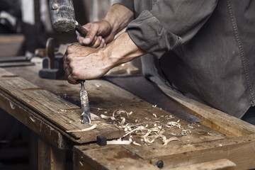 Wall Mural - Carpenter with a hammer and chisel