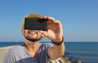 Sticker - Smiling man taking selfie at the beach