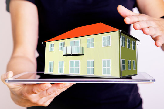 Hand holding Tablet PC with 3d house