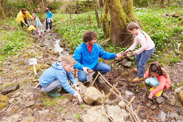 children and adults carrying out conservation work on stream