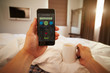 © Monkey Business - Man In Bed Looking At Health Monitoring App On Mobile Phone