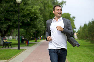 Wall Mural - Casual young man walking in the summer park