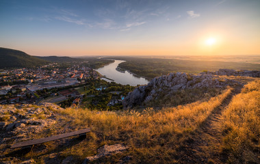 Wall Mural - View of Small City with River from the Hill at Sunset