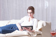 © Jürgen Hüls - attractive woman reading on tablet on couch