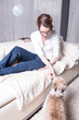 © Jürgen Hüls - attractive woman on couch feeding her dog
