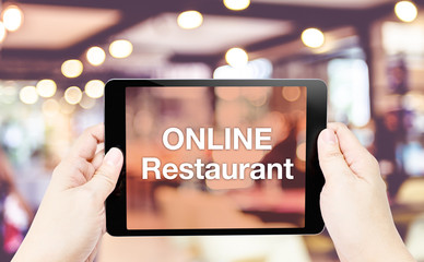 Poster - Hand hold tablet with Online restaurant word on screen with blur