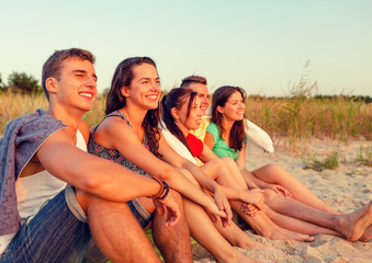 Wall Mural - smiling friends in sunglasses on summer beach