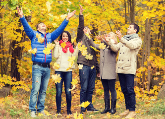 Canvas Print - group of smiling men and women in autumn park