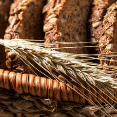 Wall Mural - Rye bread with seeds in the basket on a wooden table