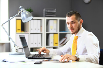 Canvas Print - Handsome businessman working with laptop in office